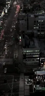 Aerial view of a busy city street at night with illuminated buildings.