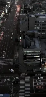 Aerial view of city traffic at night with vibrant street lights.