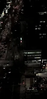 Nighttime aerial view of urban city traffic and glowing street lights.