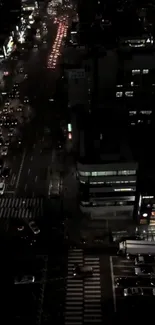 Aerial night view of city street with traffic and glowing lights.