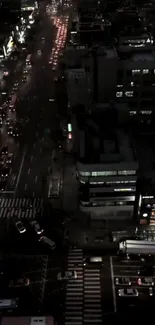 Aerial view of a city at night with busy traffic and illuminated buildings.