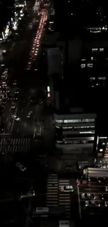 Aerial view of city night traffic with glowing lights and bustling streets.