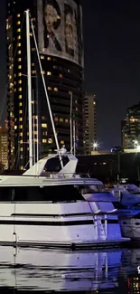 Yacht in a city harbor at night with reflections.