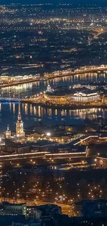 Aerial view of a city illuminated at night with glowing lights and a river.