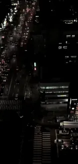 Aerial view of a vibrant city at night with illuminated streets and buildings.