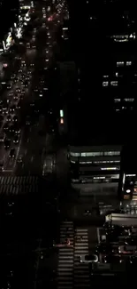 Aerial night view of a bustling city street with illuminated buildings.