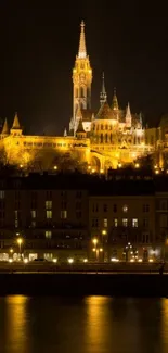 Night view of lit-up cathedral by river with reflection.