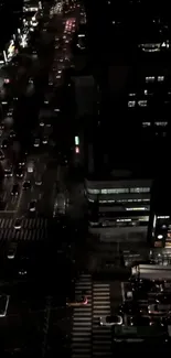 Aerial night view of city streets with glowing lights.