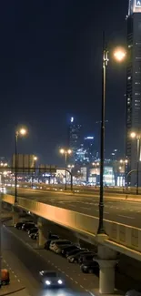 Nighttime cityscape with highway and skyscrapers illuminated by streetlights.