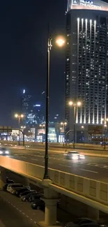 Nighttime city view with illuminated highways and tall buildings.