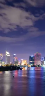 Vibrant night cityscape with skyline and water reflection.