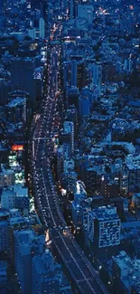 Aerial view of city at night, illuminated with bright lights and busy streets.