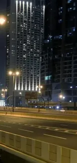 Illuminated skyscrapers with dark city road at night.