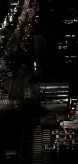 Aerial view of night city streets with bright lights.