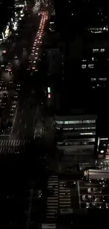 A bustling city street illuminated by night lights.