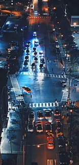 Aerial view of city street with vibrant night lights and traffic.