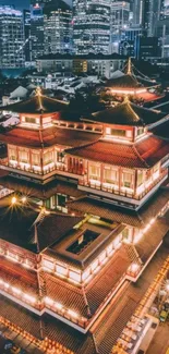 Illuminated temple against city skyline at night.