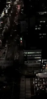 Night cityscape with urban roads and vibrant lights viewed from above.