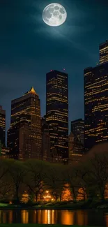 A calm city park with a full moon over skyscrapers at night.