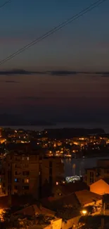 Beautiful cityscape at night with illuminated harbor and dark sky.