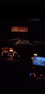 Night drive with illuminated car dashboard in dark, serene road view.