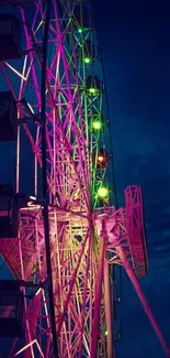 Vibrant Ferris wheel glowing at night with neon lights against a dark blue sky.