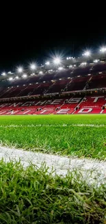 Vibrant night view of a football stadium with green grass field.