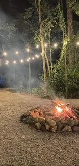 Campfire glowing under string lights in a peaceful forest setting at night.