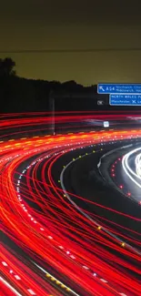 Mobile wallpaper of red light trails on a highway at night.