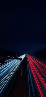 Dark highway with vibrant blue and red light trails in the night.