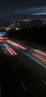 Highway with light trails under city night sky.