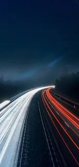 Vibrant highway light trails at night under a dark blue sky.