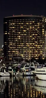 Nighttime marina cityscape with boats and glowing building reflections.