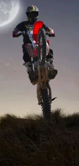 Motocross rider jumps under a moonlit sky in dramatic wallpaper.