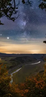 Starry night sky over a serene valley landscape.