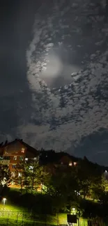 Moonlit night sky over urban houses with clouds.