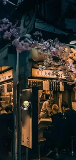 Vibrant street food scene at night with cherry blossoms overhead.