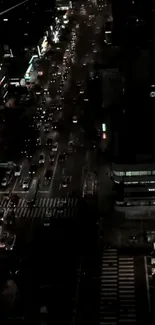 Aerial view of city at night with traffic and illuminated streets.