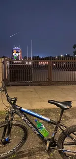 Bicycle parked under a serene night sky with a distant cityscape.