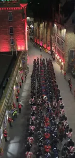 Marching band parade on illuminated city street at night.