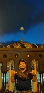 Nighttime mosque with golden lights and deep blue sky.