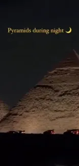 Night view of illuminated pyramids with a starry sky background.