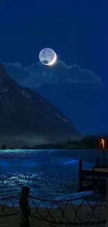 Moonlit lake with mountains at night.