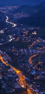 A village at night with glowing street lights and winding roads.