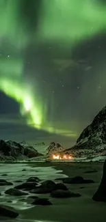 Green aurora lights above snowy mountains by the sea at night.