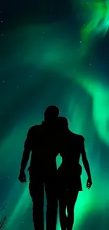 A silhouetted couple under the Northern Lights.