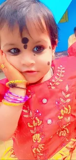 Colorful child in red traditional attire, charming look.