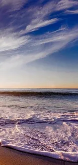 Serene beach and ocean under a bright blue sky at sunset.