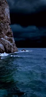 Dark ocean cliff with moody night sky.