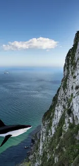 Shark gracefully swimming near an ocean cliff under a clear blue sky.